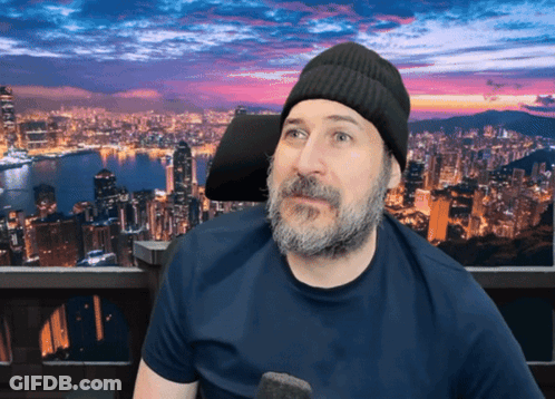 A Man With A Beard Wearing A Beanie And A Blue Shirt GIF