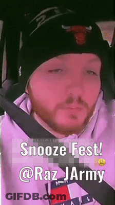 A Man With A Beard Wearing A Beanie And A Tommy Hilfiger Hoodie Is Sitting In A Car . GIF