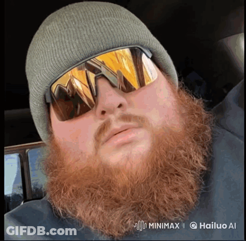 A Man With A Beard Wearing A Beanie And Sunglasses Has A Watermark That Says Hailuo Ai GIF