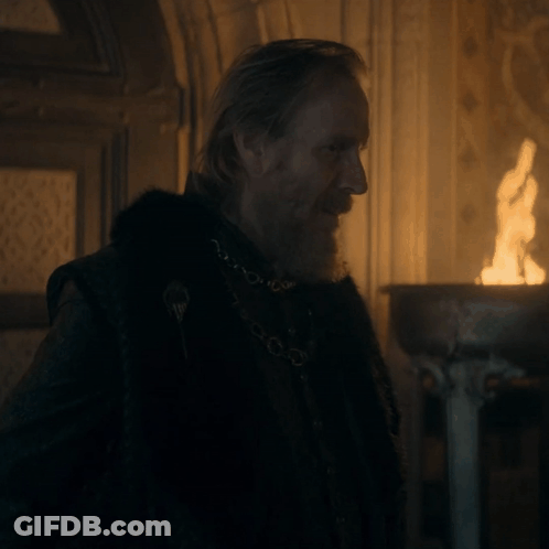 A Man With A Beard Wearing A Black Coat And A Chain Around His Neck GIF
