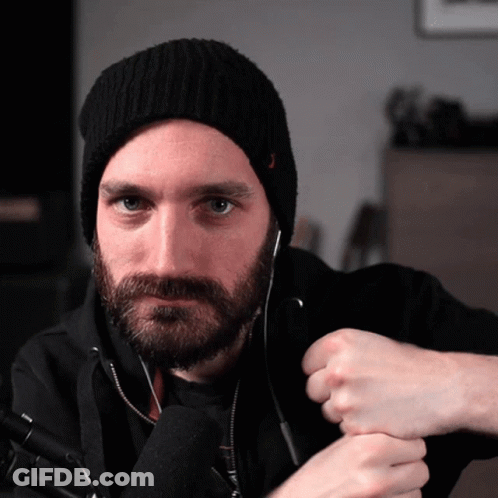A Man With A Beard Wearing A Black Hat And Headphones GIF