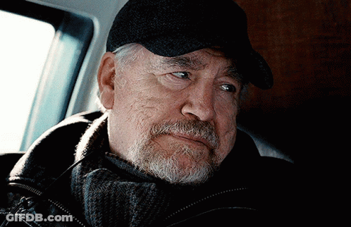 A Man With A Beard Wearing A Black Hat And Scarf GIF