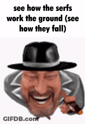A Man With A Beard Wearing A Black Hat Is Smiling And Holding A Gun GIF