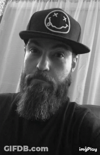 A Man With A Beard Wearing A Black Hat With A Smiley Face On It GIF
