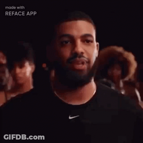 A Man With A Beard Wearing A Black Nike Shirt Is Standing In Front Of A Crowd Of People . GIF