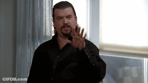 A Man With A Beard Wearing A Black Shirt Is Making A Hand Gesture GIF