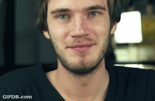 A Man With A Beard Wearing A Black Shirt Is Smiling GIF