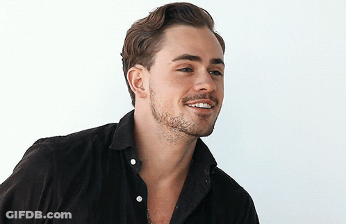 A Man With A Beard Wearing A Black Shirt Smiles GIF
