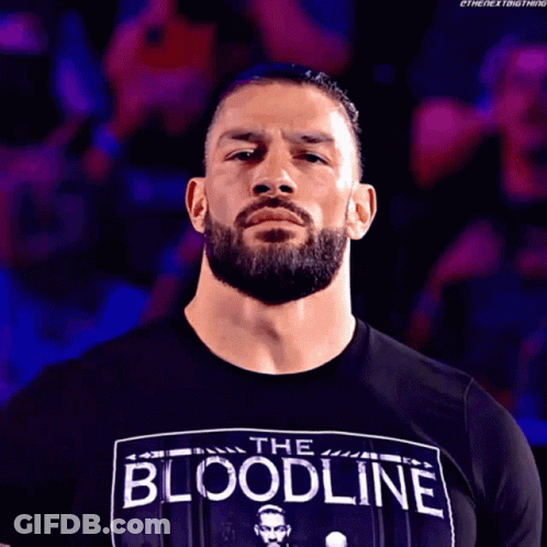 A Man With A Beard Wearing A Black Shirt That Says The Bloodline GIF