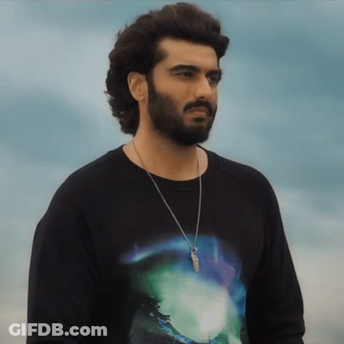A Man With A Beard Wearing A Black Shirt With A Necklace Around His Neck GIF