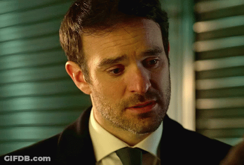A Man With A Beard Wearing A Black Suit And Tie GIF