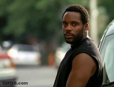 A Man With A Beard Wearing A Black Tank Top Is Standing Next To A Car GIF