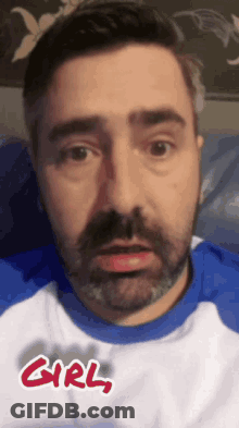 A Man With A Beard Wearing A Blue And White Shirt With The Word Girl Written On It . GIF
