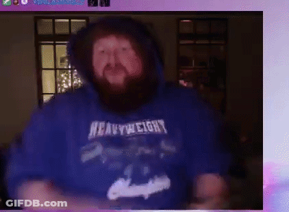 A Man With A Beard Wearing A Blue Heavyweight Hoodie Is Dancing . GIF