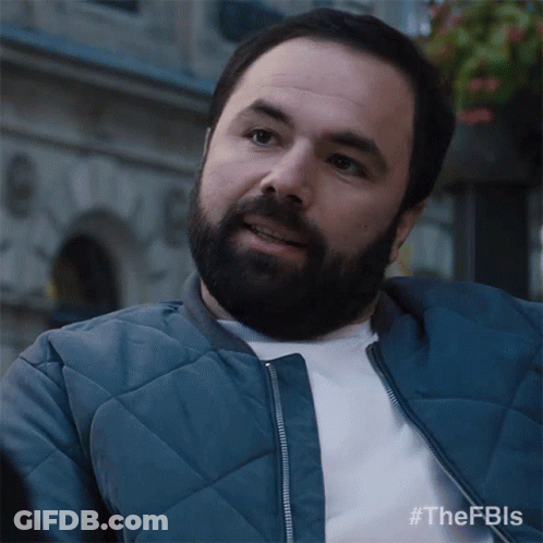 A Man With A Beard Wearing A Blue Jacket And A White Shirt GIF