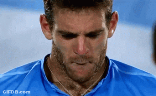 A Man With A Beard Wearing A Blue Shirt Is Looking Down . GIF