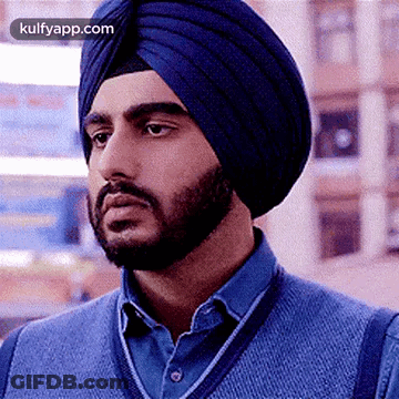 A Man With A Beard Wearing A Blue Turban And A Blue Sweater . GIF