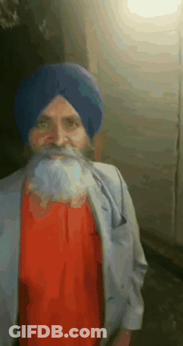 A Man With A Beard Wearing A Blue Turban And A Red Shirt GIF