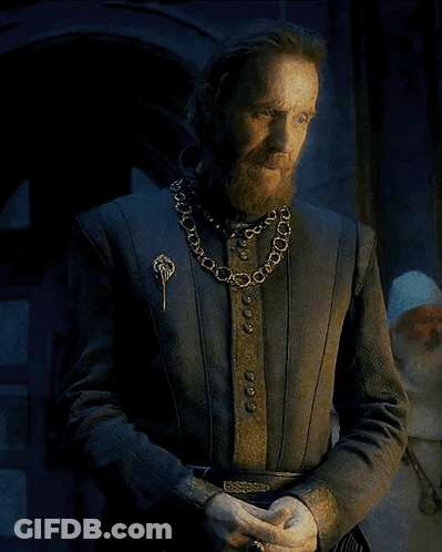 A Man With A Beard Wearing A Chain Around His Neck And A Brooch GIF