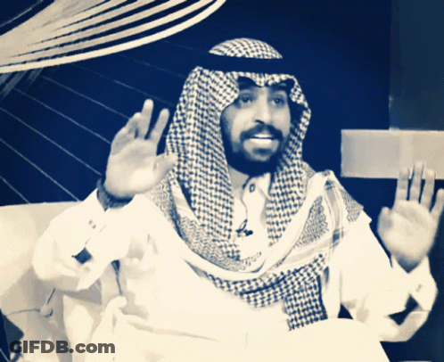 A Man With A Beard Wearing A Checked Scarf And A White Shirt GIF