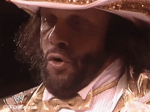 A Man With A Beard Wearing A Cowboy Hat And A Bow Tie With A W On His Chest GIF