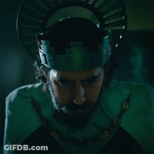 A Man With A Beard Wearing A Crown And A Chain Around His Neck GIF