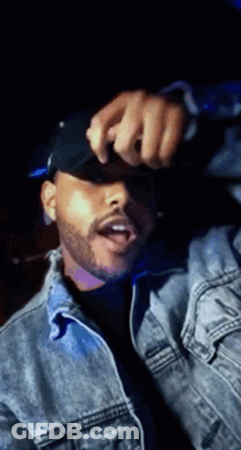 A Man With A Beard Wearing A Denim Jacket And A Black Hat . GIF