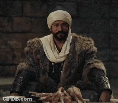 A Man With A Beard Wearing A Fur Coat And Turban . GIF