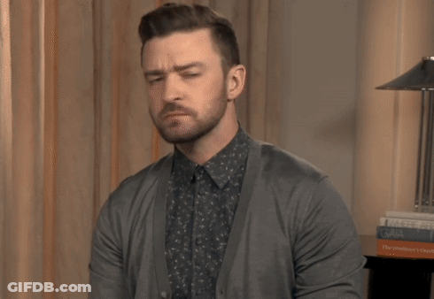 A Man With A Beard Wearing A Gray Cardigan GIF