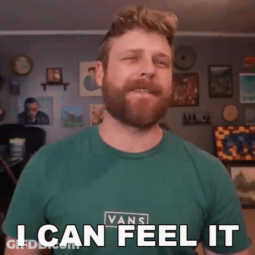 A Man With A Beard Wearing A Green Vans Shirt Says I Can Feel It GIF