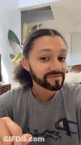 A Man With A Beard Wearing A Grey Champion Shirt GIF