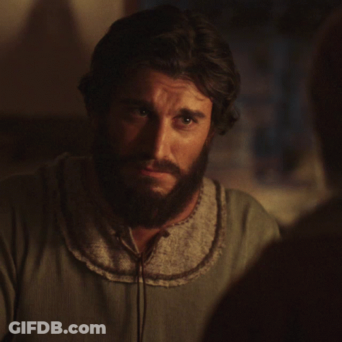 A Man With A Beard Wearing A Grey Shirt Smiles GIF