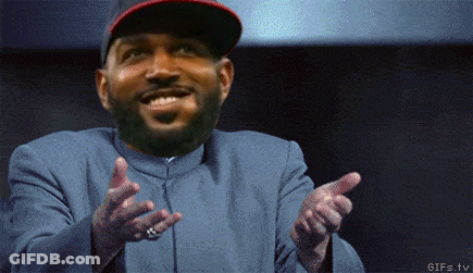 A Man With A Beard Wearing A Hat And A Blue Jacket Is Pointing At Something GIF