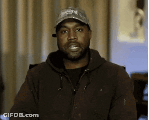A Man With A Beard Wearing A Hat And A Jacket Looks At The Camera GIF