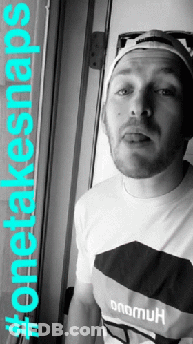 A Man With A Beard Wearing A Hat And A Shirt That Says Onemuk GIF