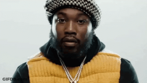 A Man With A Beard Wearing A Hat And A Yellow Vest . GIF