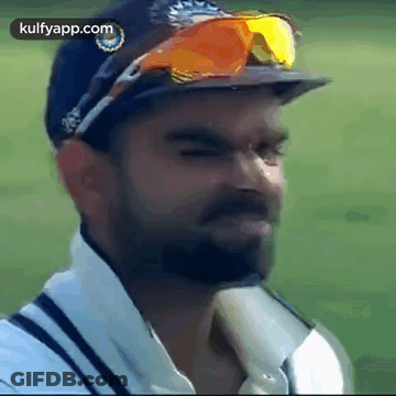 A Man With A Beard Wearing A Hat And Sunglasses Is Making A Funny Face . GIF