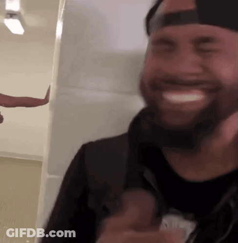 A Man With A Beard Wearing A Hat Is Smiling GIF