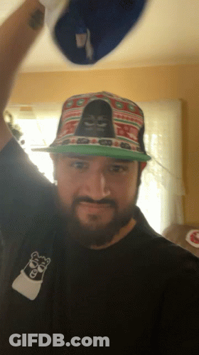 A Man With A Beard Wearing A Hat With A Gorilla On It GIF