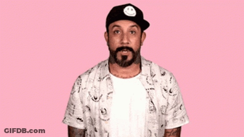 A Man With A Beard Wearing A Hat With A Smiley Face On It Says Oops I Did It Again GIF
