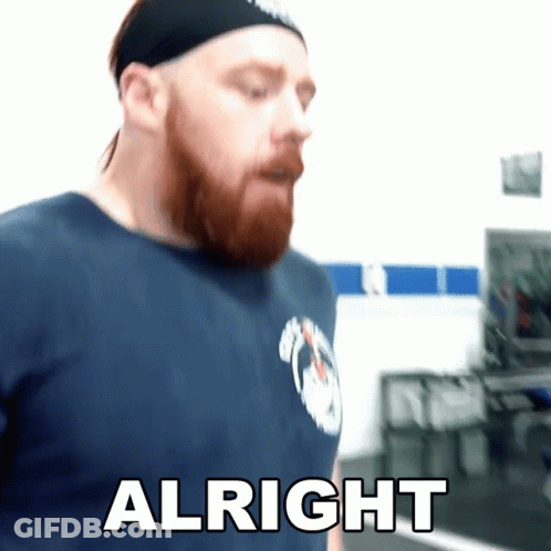 A Man With A Beard Wearing A Headband And A Blue Shirt Says Alright GIF