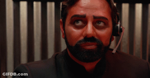 A Man With A Beard Wearing A Headset Looks At The Camera GIF
