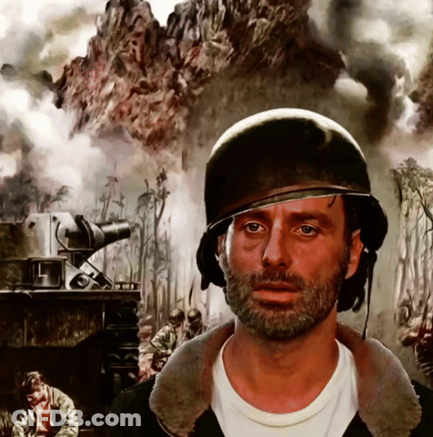 A Man With A Beard Wearing A Helmet In Front Of A Painting Of Soldiers GIF