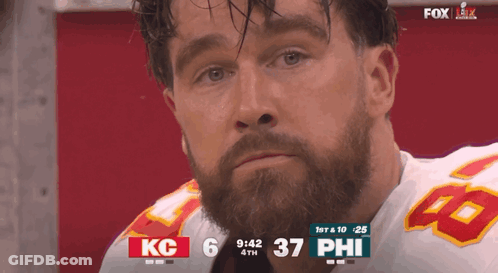 A Man With A Beard Wearing A Kc Jersey Is Watching A Football Game GIF