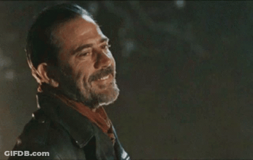A Man With A Beard Wearing A Leather Jacket And Scarf Is Smiling . GIF