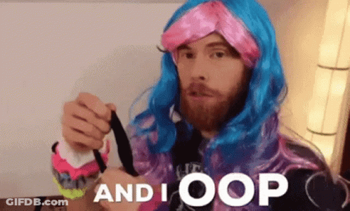A Man With A Beard Wearing A Pink And Blue Wig Is Holding A Black Object And Says And I Oops GIF