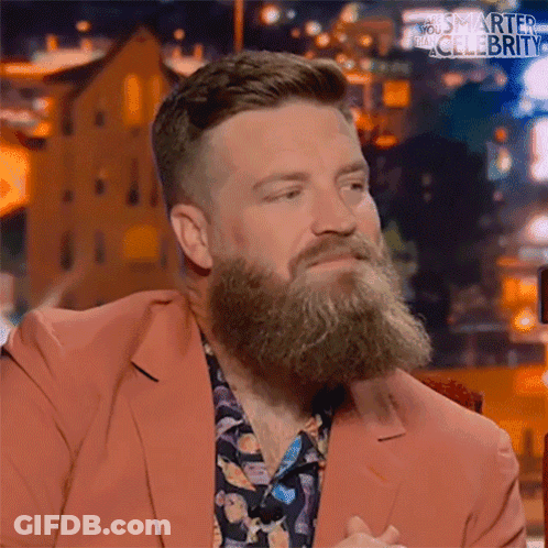 A Man With A Beard Wearing A Pink Suit And A Floral Shirt GIF
