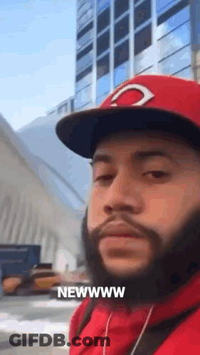 A Man With A Beard Wearing A Red Hat And A Red Hoodie Says Newwww GIF