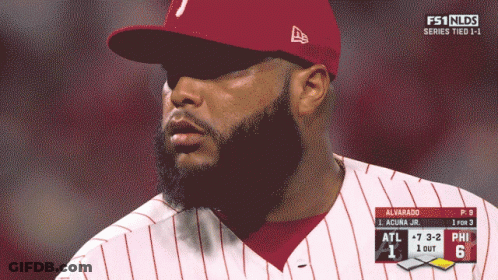 A Man With A Beard Wearing A Red Hat And A White And Red Striped Shirt GIF