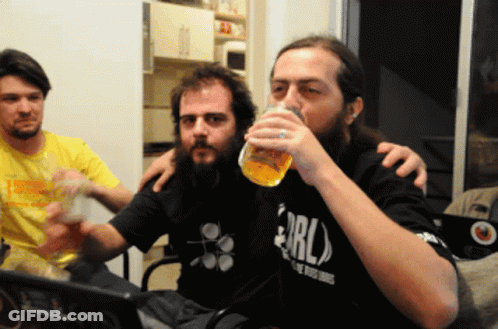 A Man With A Beard Wearing A Shirt That Says Erl Drinks From A Glass GIF